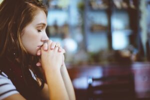 Young woman praying for Ways Hope Can Help Overcome Challenges