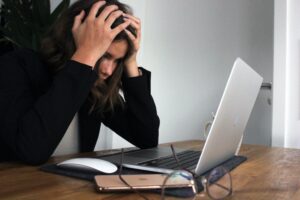 Woman with hands over head staring at a computer trying to learn how to quit well