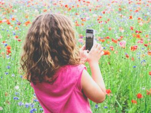 Young girl in a pasture of wild flowers cultivating awe